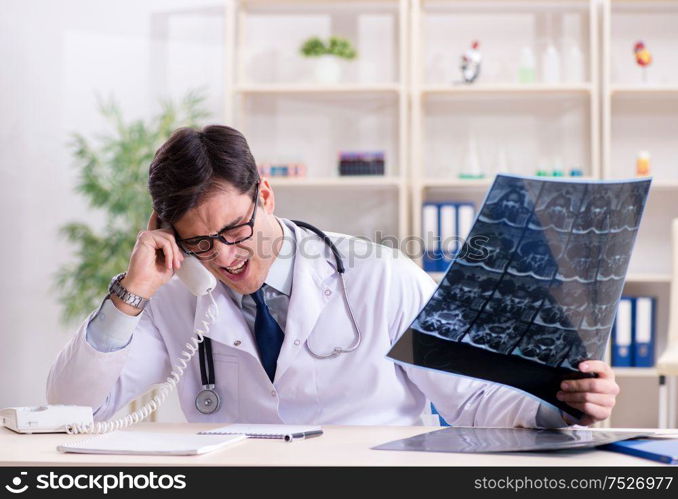 The young doctor looking at x-ray images in clinic. Young doctor looking at x-ray images in clinic