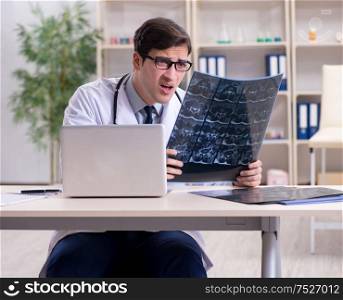 The young doctor looking at x-ray images in clinic. Young doctor looking at x-ray images in clinic