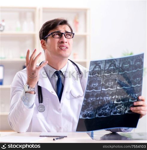 The young doctor looking at x-ray images in clinic. Young doctor looking at x-ray images in clinic