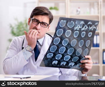 The young doctor looking at x-ray images in clinic. Young doctor looking at x-ray images in clinic