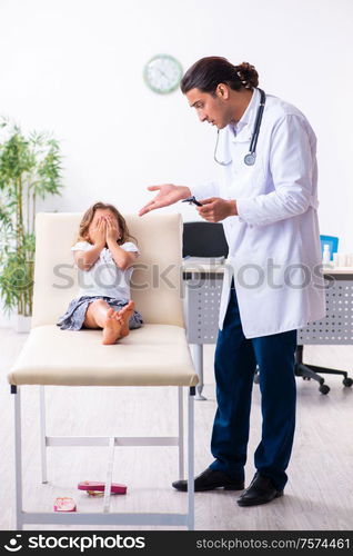 The young doctor pediatrician with small girl. Young doctor pediatrician with small girl