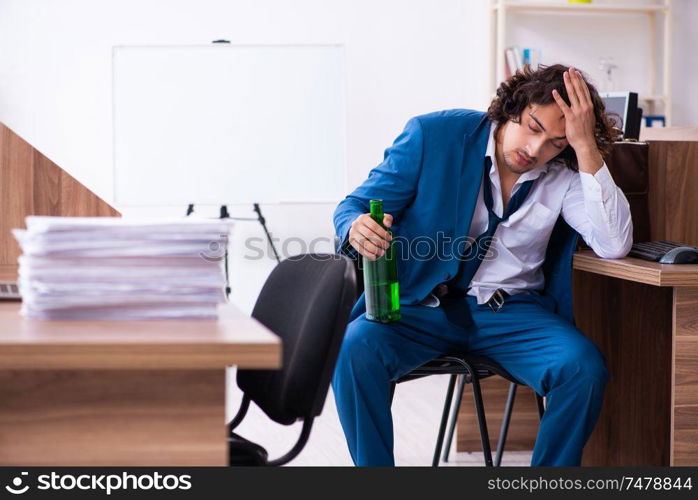 The young drunk employee in the office . Young drunk employee in the office