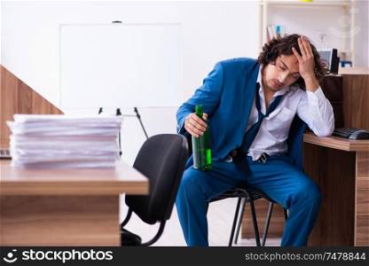 The young drunk employee in the office . Young drunk employee in the office