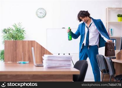 The young drunk employee in the office . Young drunk employee in the office