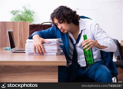 The young drunk employee in the office. Young drunk employee in the office
