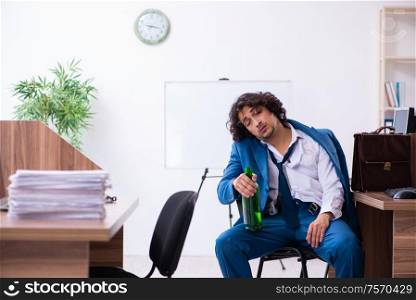 The young drunk employee in the office. Young drunk employee in the office