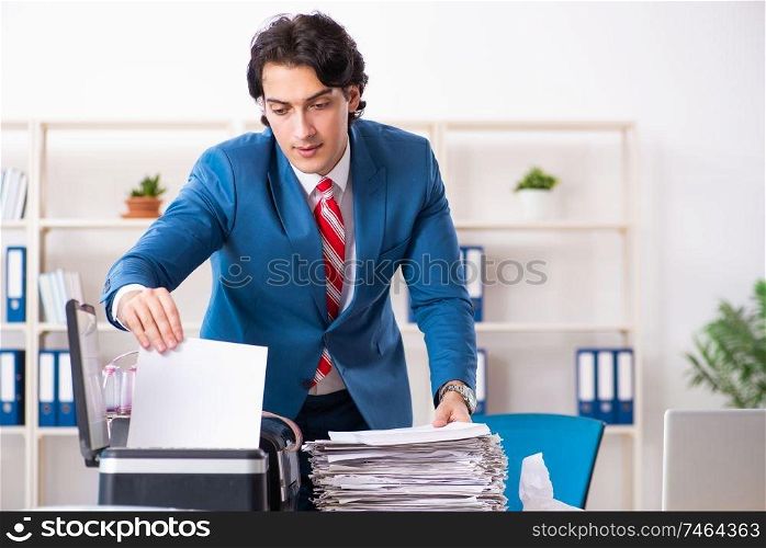 The young employee making copies at copying machine . Young employee making copies at copying machine 