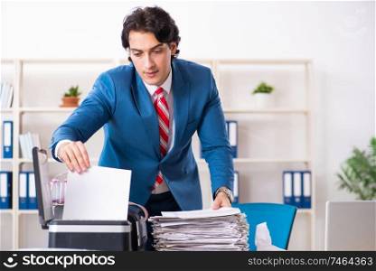 The young employee making copies at copying machine . Young employee making copies at copying machine 
