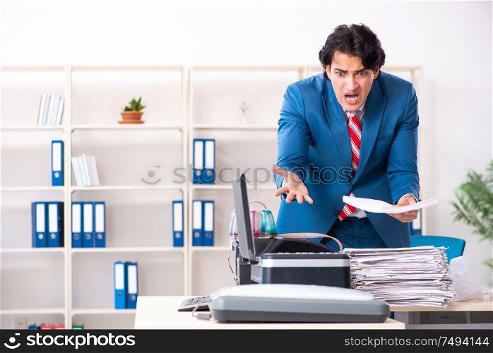 The young employee making copies at copying machine. Young employee making copies at copying machine