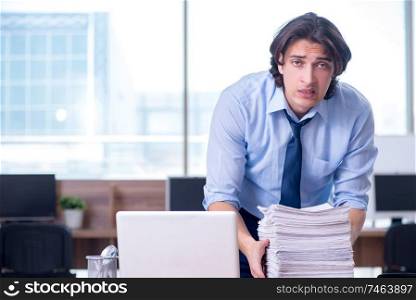 The young employee unhappy with excessive work . Young employee unhappy with excessive work 