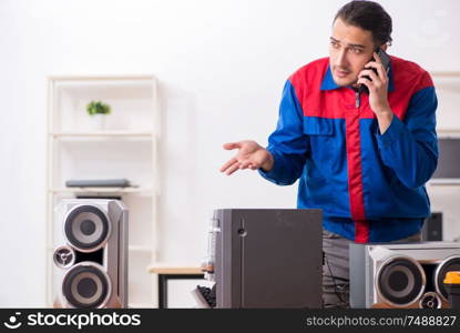 The young engineer repairing musical hi-fi system. Young engineer repairing musical hi-fi system