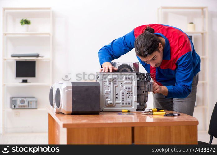 The young engineer repairing musical hi-fi system. Young engineer repairing musical hi-fi system