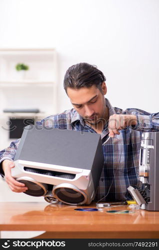 The young engineer repairing musical hi-fi system. Young engineer repairing musical hi-fi system