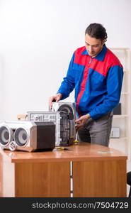 The young engineer repairing musical hi-fi system. Young engineer repairing musical hi-fi system