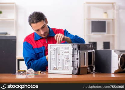 The young engineer repairing musical hi-fi system. Young engineer repairing musical hi-fi system