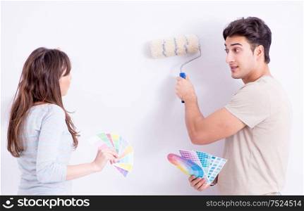 The young family doing renovation at home - painting walls. Young family doing renovation at home - painting walls