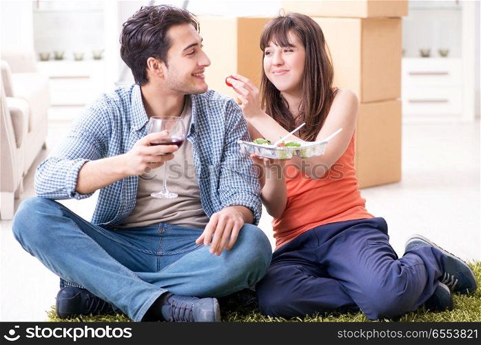 The young family eating food in new apartment after moving in. Young family eating food in new apartment after moving in