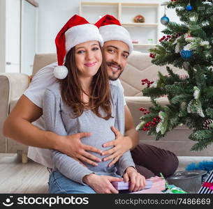 The young family expecting child baby celebrating christmas. Young family expecting child baby celebrating christmas