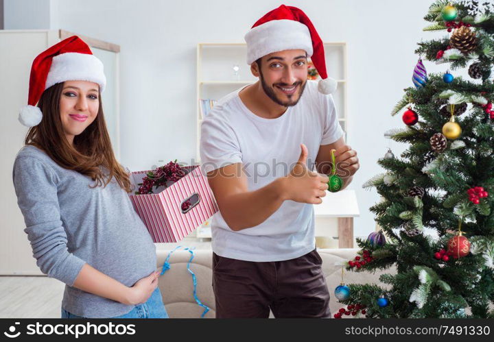 The young family expecting child baby celebrating christmas. Young family expecting child baby celebrating christmas