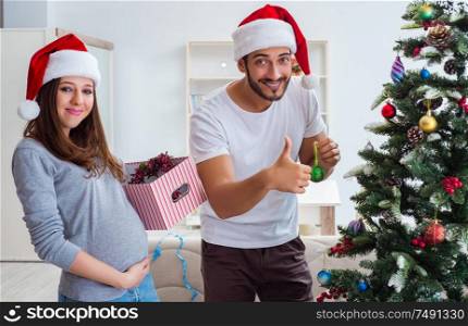 The young family expecting child baby celebrating christmas. Young family expecting child baby celebrating christmas