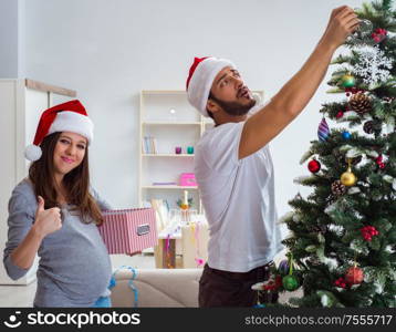 The young family expecting child baby celebrating christmas. Young family expecting child baby celebrating christmas