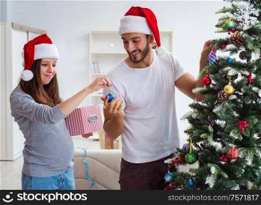 The young family expecting child baby celebrating christmas. Young family expecting child baby celebrating christmas