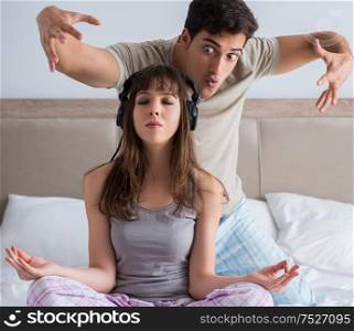 The young family meditating in the bed bedroom. Young family meditating in the bed bedroom