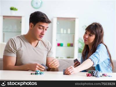 The young family playing cards at home. Young family playing cards at home
