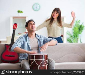 The young family singing and playing music at home. Young family singing and playing music at home