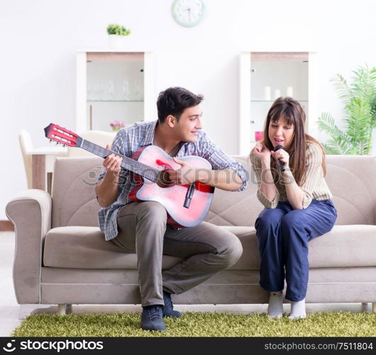 The young family singing and playing music at home. Young family singing and playing music at home