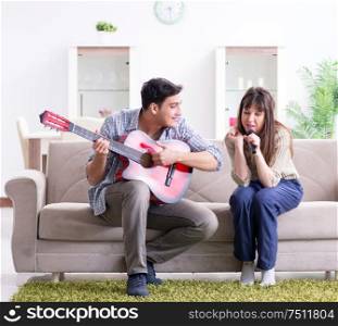 The young family singing and playing music at home. Young family singing and playing music at home