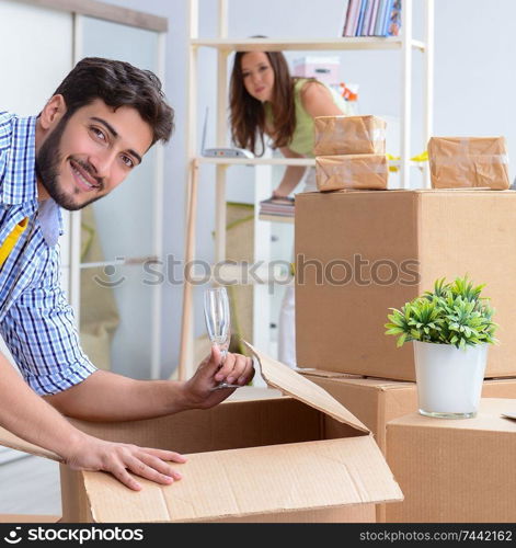 The young family unpacking at new house with boxes. Young family unpacking at new house with boxes