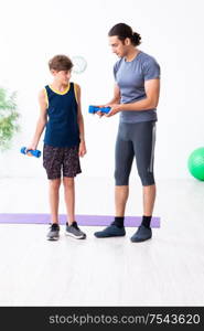 The young father and his son doing exercises. Young father and his son doing exercises