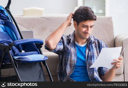 The young father assembling baby pram at home. Young father assembling baby pram at home