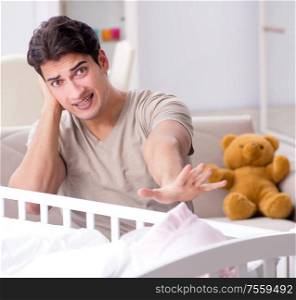 The young father dad frustrated at crying baby. Young father dad frustrated at crying baby