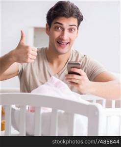 The young father enjoying time with newborn baby at home. Young father enjoying time with newborn baby at home