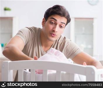 The young father enjoying time with newborn baby at home. Young father enjoying time with newborn baby at home