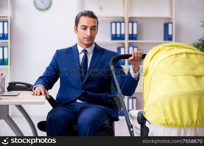 The young father looking after newborn in the office. Young father looking after newborn in the office