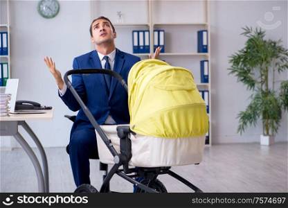 The young father looking after newborn in the office. Young father looking after newborn in the office