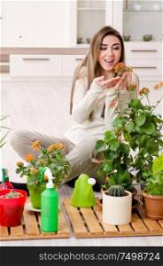 The young female gardener with plants indoors. Young female gardener with plants indoors