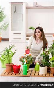The young female gardener with plants indoors. Young female gardener with plants indoors