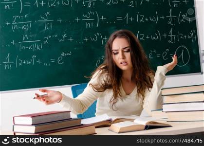 The young female math teacher in front of chalkboard. Young female math teacher in front of chalkboard