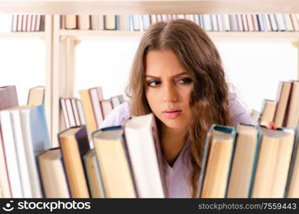 The young female student preparing for exams at library. Young female student preparing for exams at library