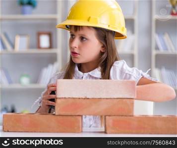 The young girl building with construction bricks. Young girl building with construction bricks