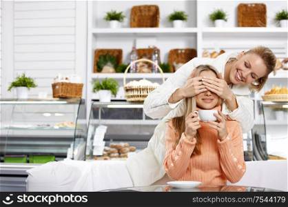 The young girl closes eyes to the girlfriend in cafe
