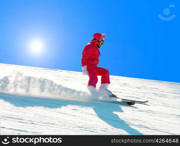 The young girl on skis goes from mountain in a spotty suit