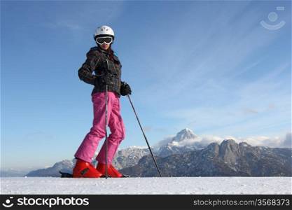 The young girl on skis in the background of mountains covered with snow