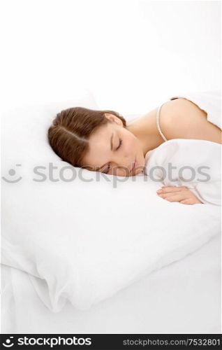 The young girl sleeps in the white bed, isolated