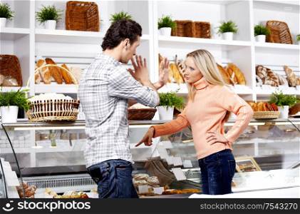 The young girl swears at the man in shop