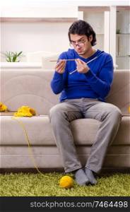 The young good looking man knitting at home. Young good looking man knitting at home